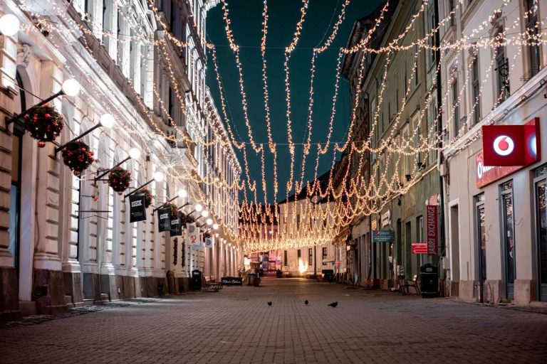 Christmas fairy lights hanging in the walking street in the middle of the city center by night